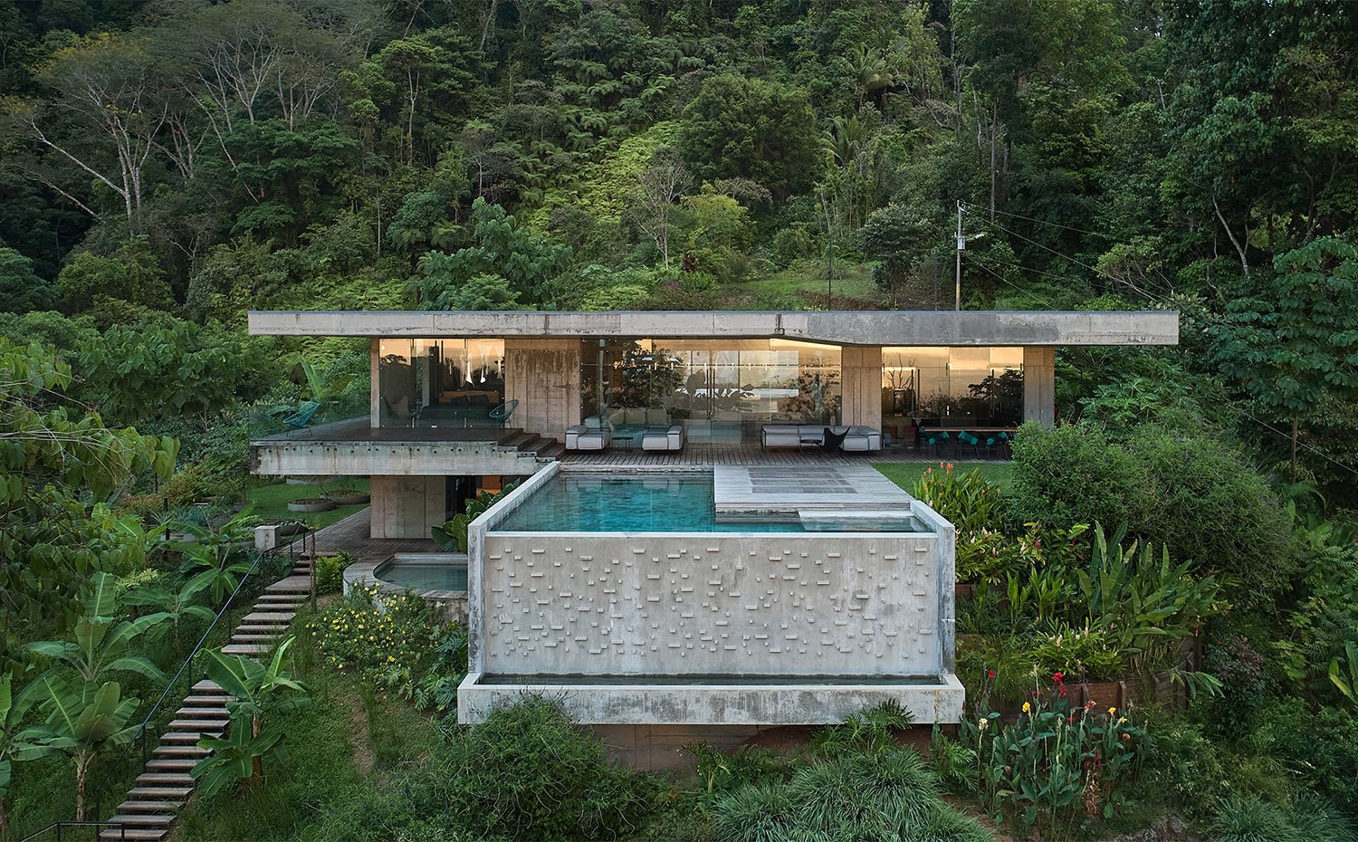 Una moderna casa de hormigón con piscina en la selva de costa rica