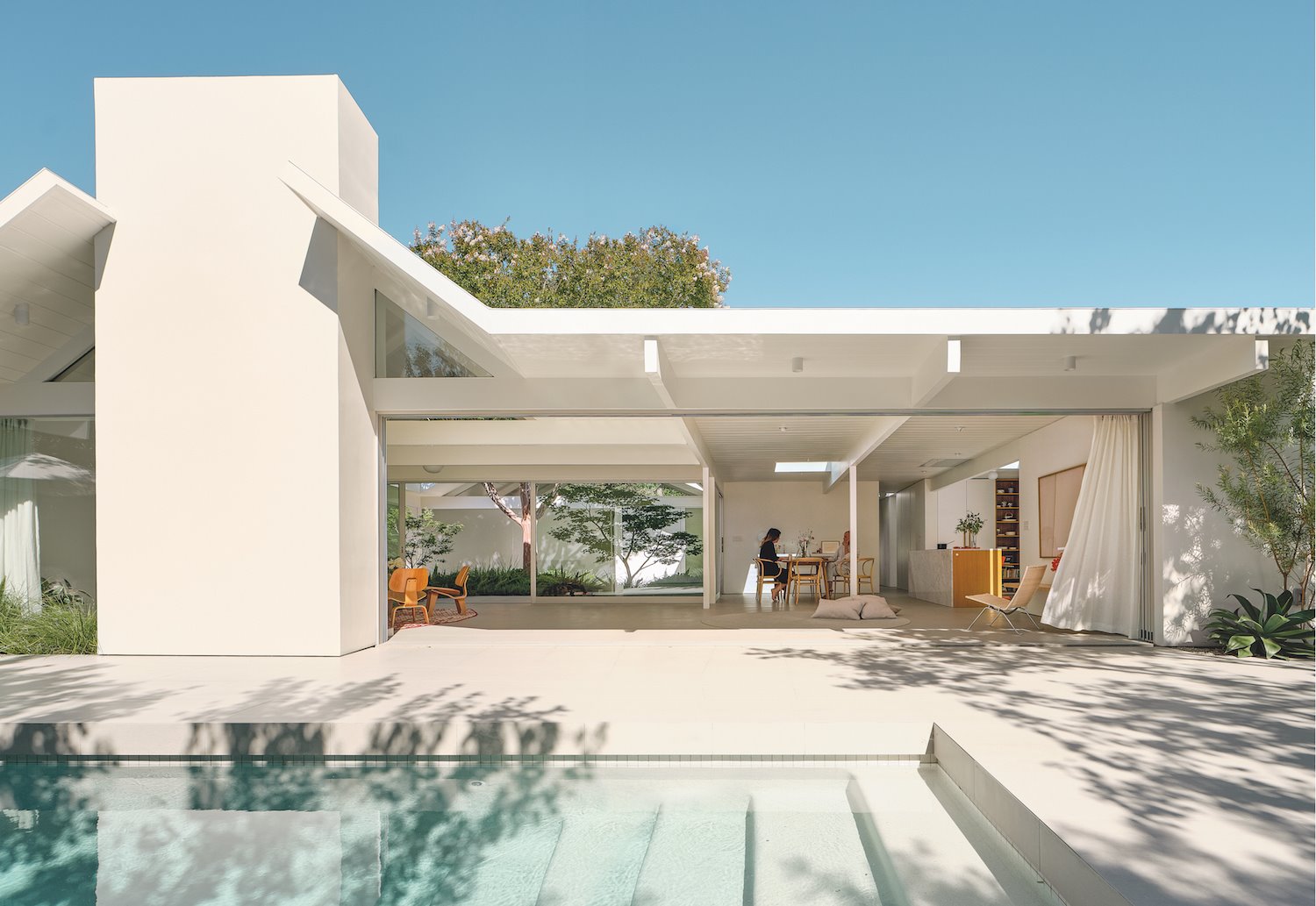 Una moderna casa blanca con piscina y un patio con árboles en Silicon Valley