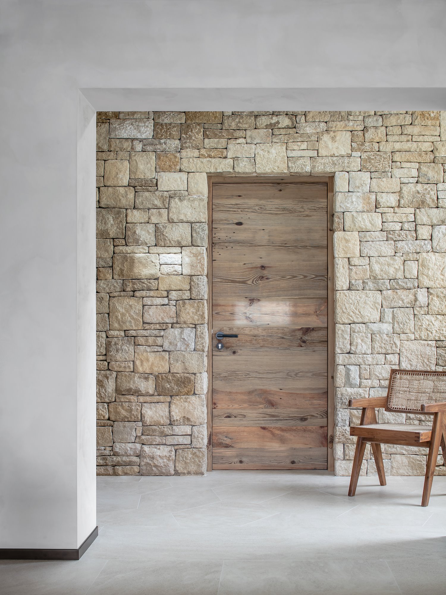 Una casa de piedra natural muy moderna con interiores de madera minimalistas