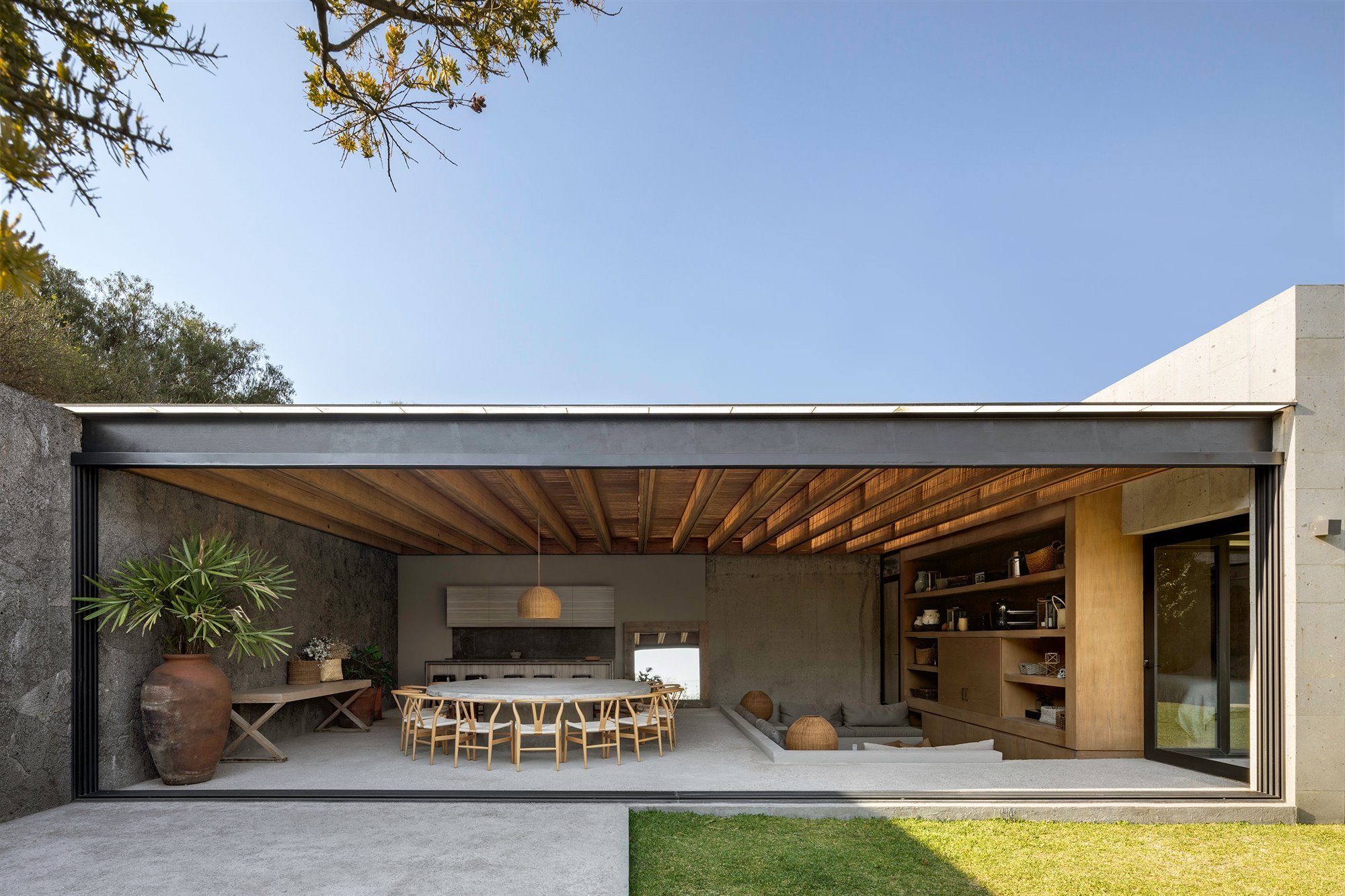 Una moderna casa en Mexico con interiores de madera y hormigón abiertos a  un patio interior