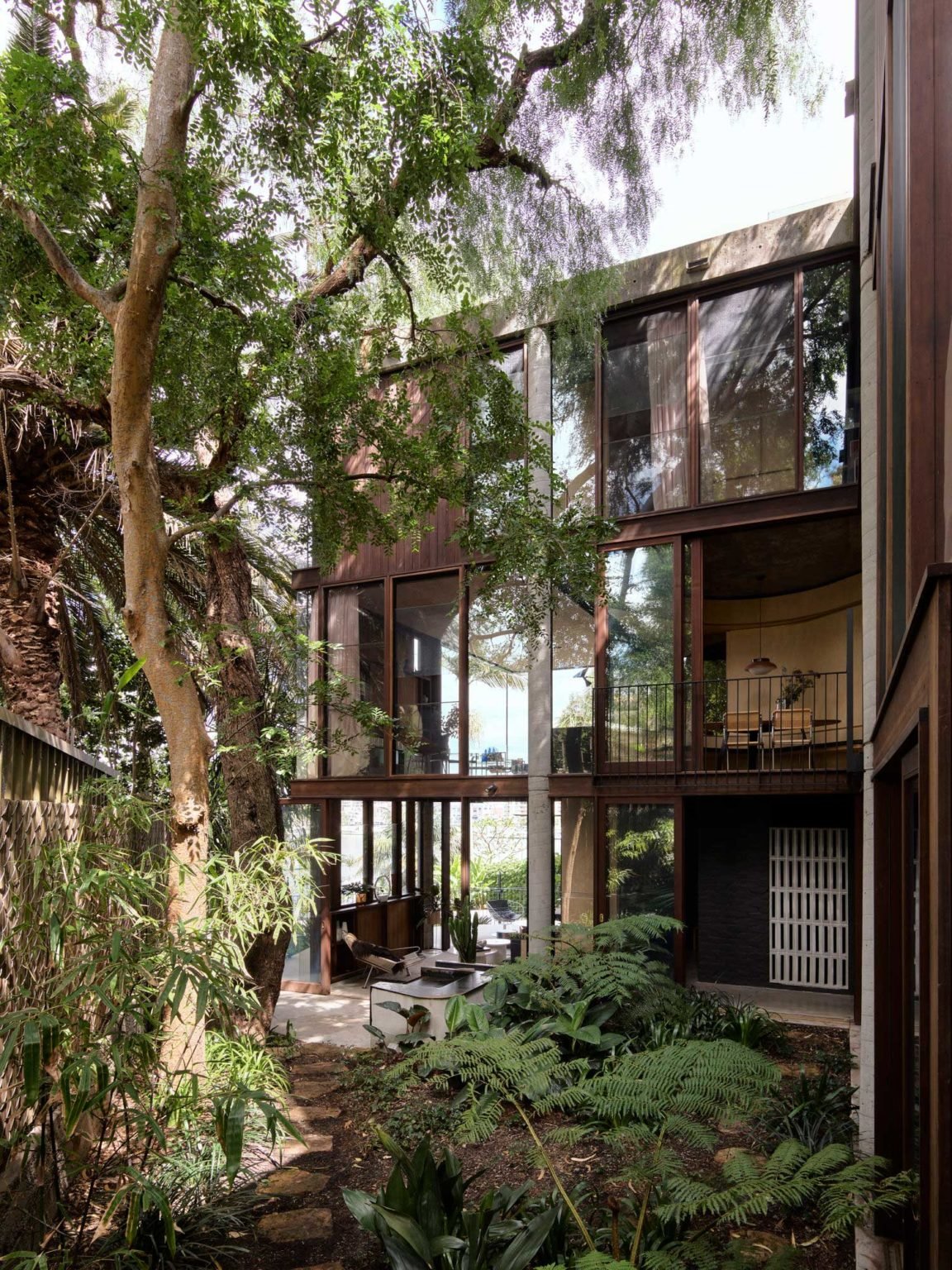 Una casa en Australia de los años 70 con las paredes de cristal y vistas al  muelle